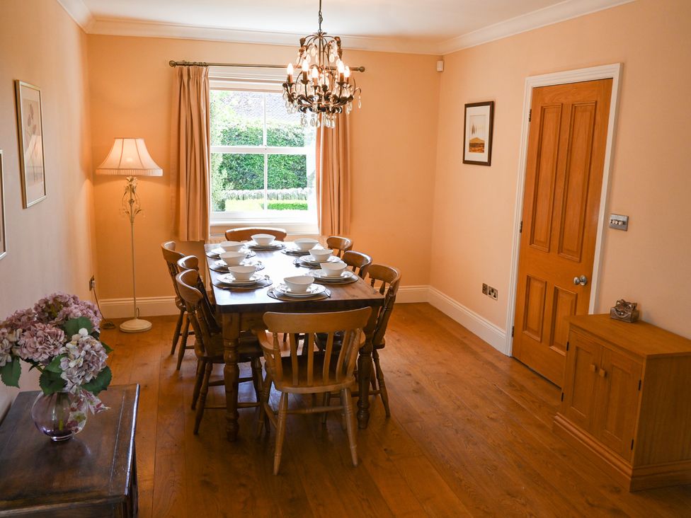 A dining room with a table set for a meal at The Garden House in Alton