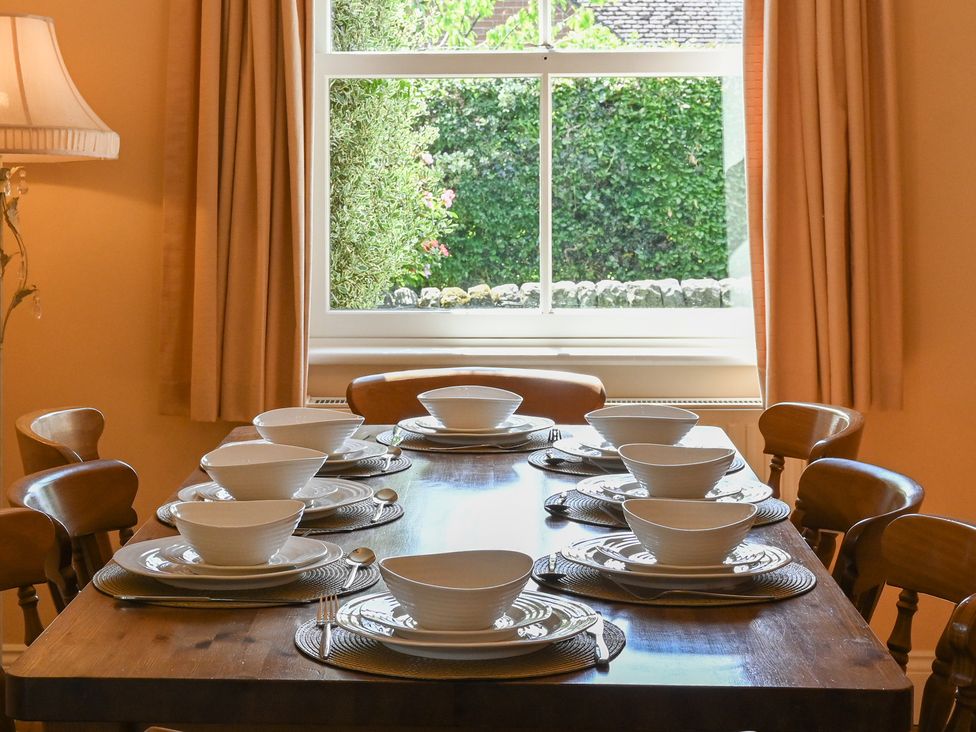 A dining room with a table set for dinner at The Garden House in Alton