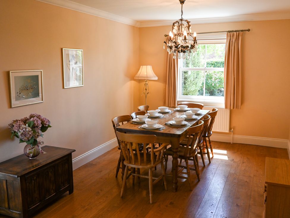 A dining room with a table set for eight at The Garden House in Alton