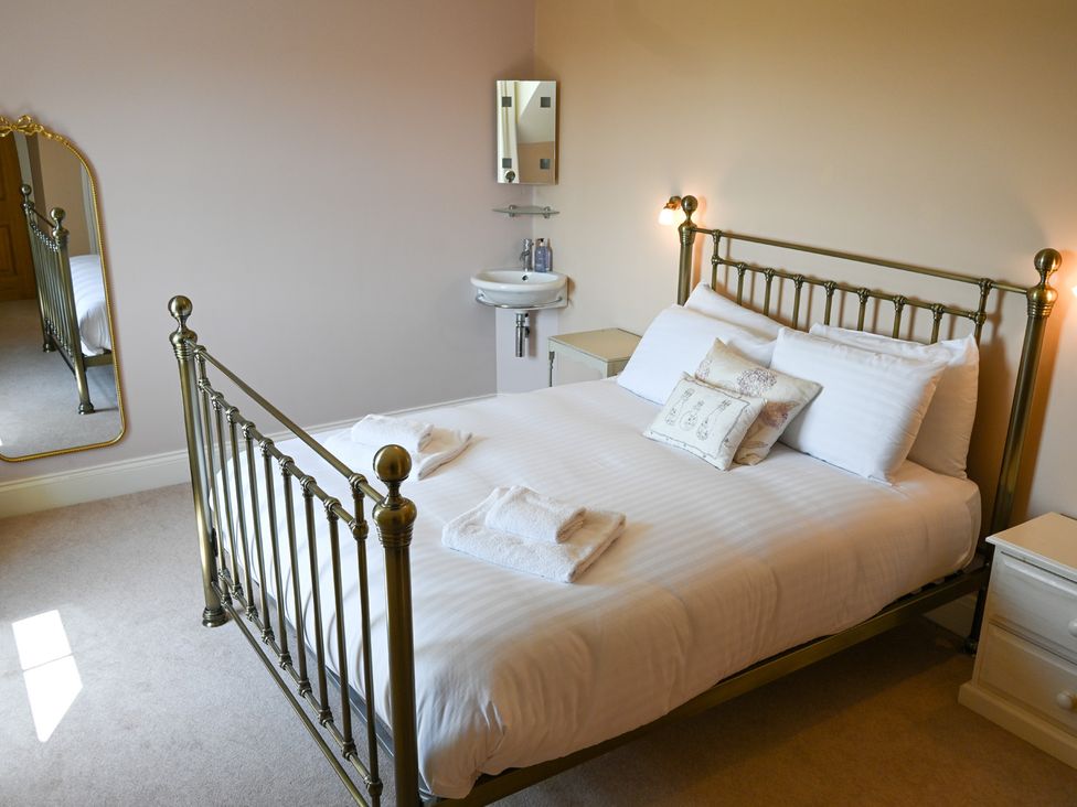 A bedroom with a bed and mirror at The Garden House in Alton