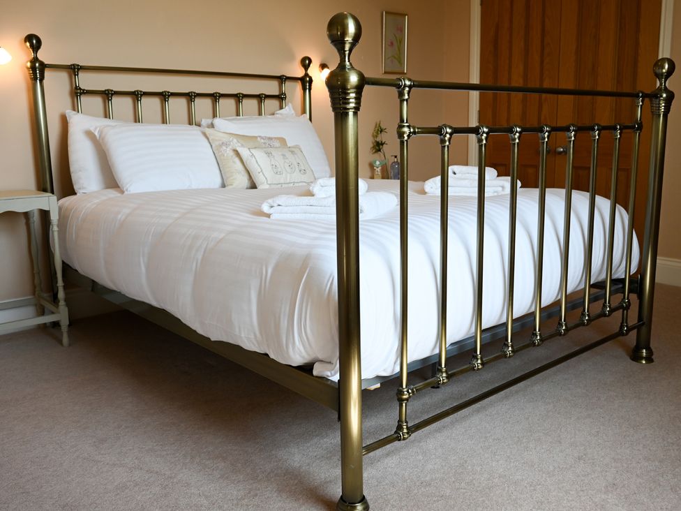 A bed with white linens and pillows in a bedroom at The Garden House in Alton