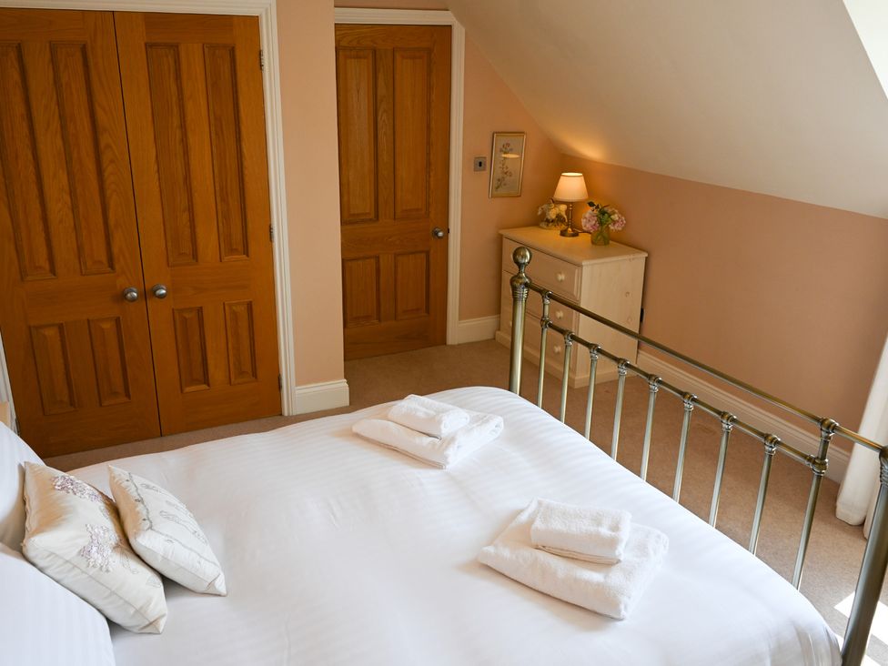 A bedroom with a bed and dresser at The Garden House in Alton