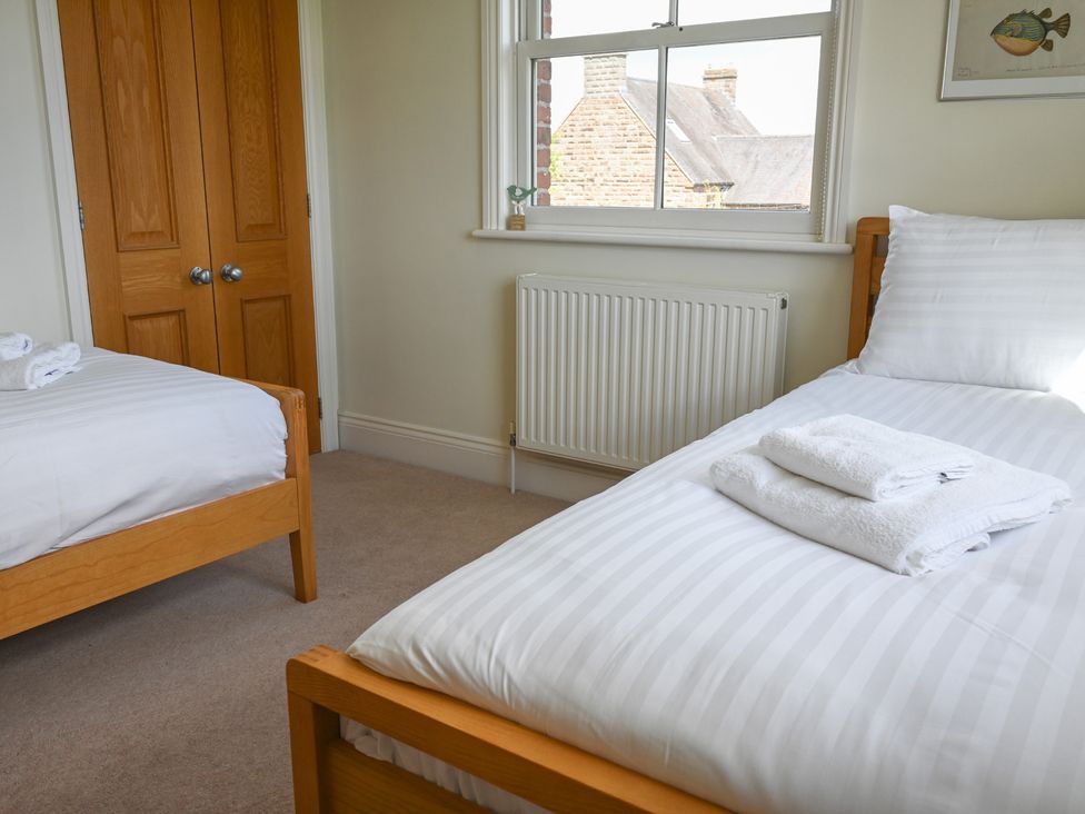 A bedroom with beds and a window at The Garden House in Alton
