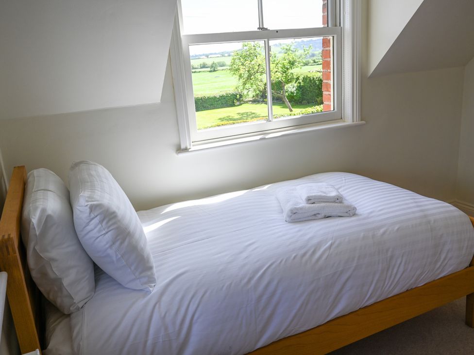 A bedroom with a bed and window at The Garden House in Alton