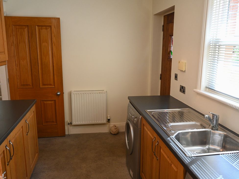 A kitchen featuring a washing machine, sink, and countertop at The Garden House in Alton