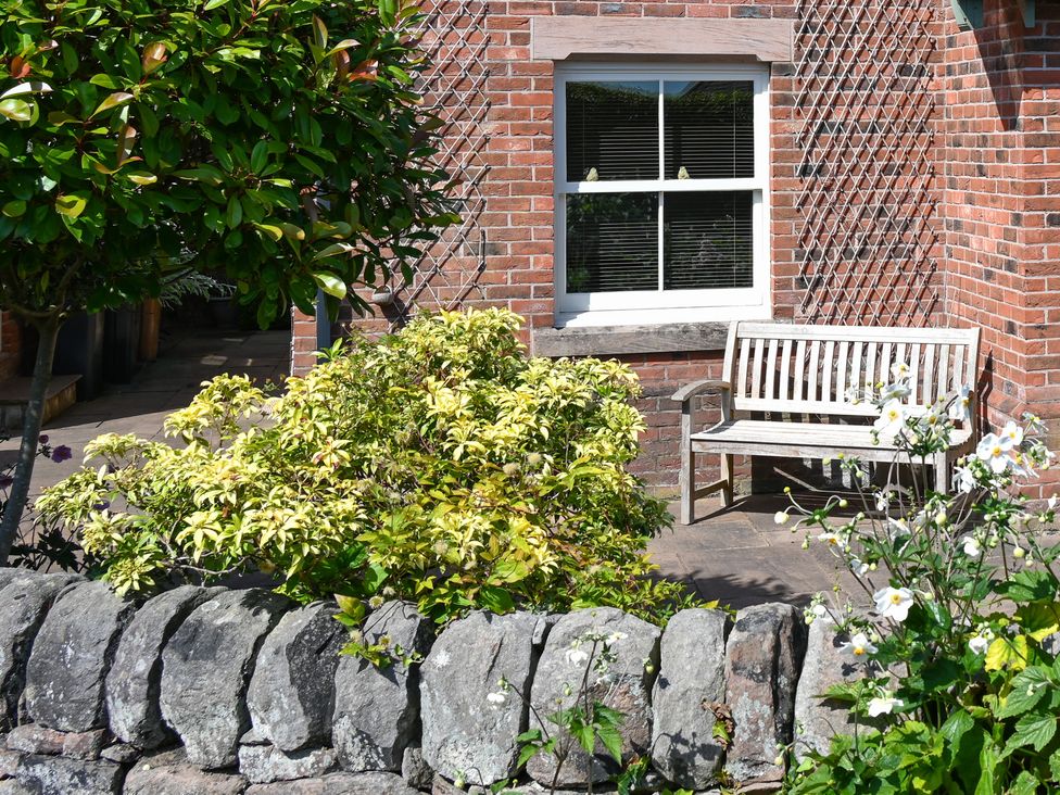 An outdoor area with a bench and greenery at The Garden House - Alton Towers & Peak District in Alton