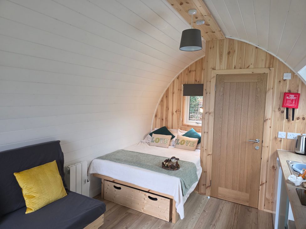 A bedroom with a bed and sofa at Bracelands - Deluxe Pod 10 in Coleford