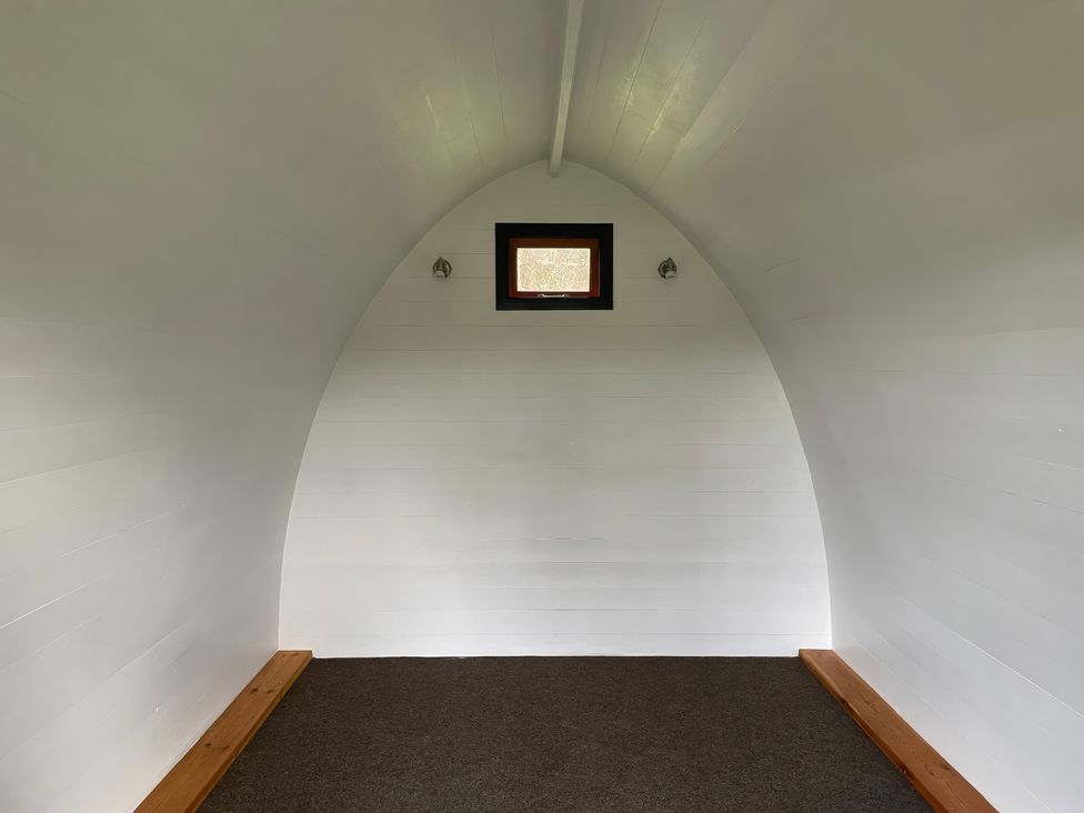 An indoor space with arched walls and a window at Bracelands - Cosy Pod 1, Coleford