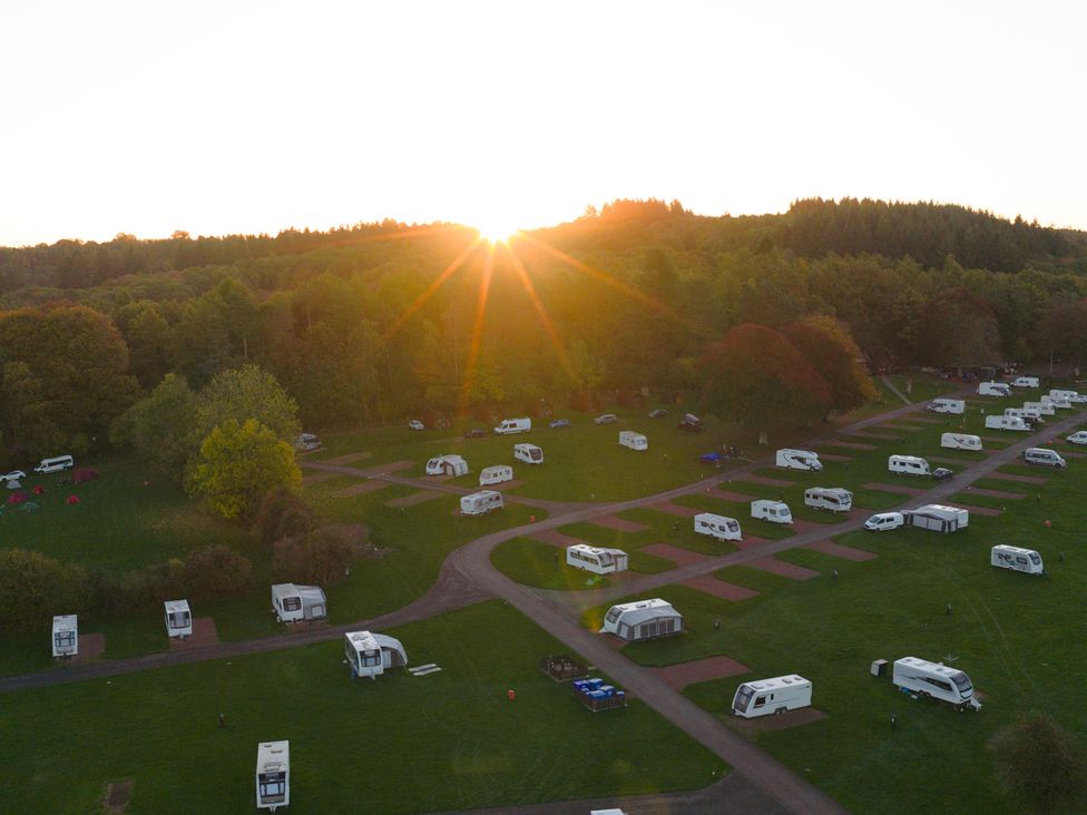 An aerial view of a campground with caravans and tents at Bracelands - Cosy Pod 1 Coleford