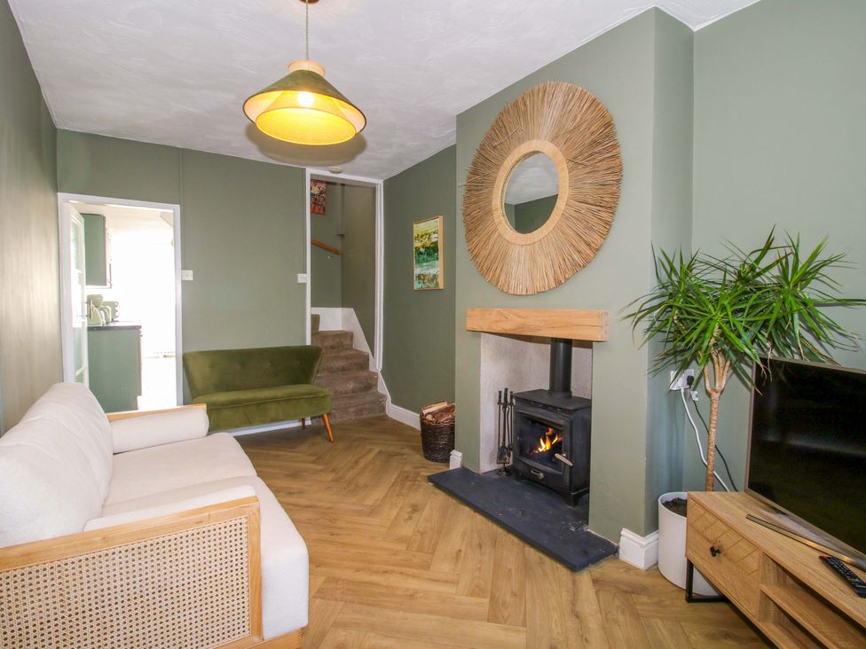 A living room with a fireplace and sofa at Cheshire Views in Malpas