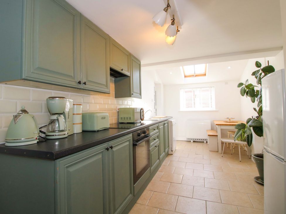 A kitchen with green cabinets and appliances at Cheshire Views in Malpas
