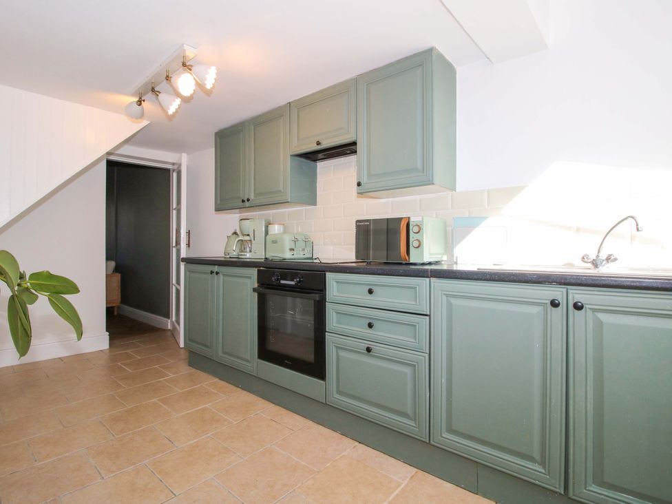 A kitchen with cabinets, stove, and microwave at Cheshire Views in Malpas