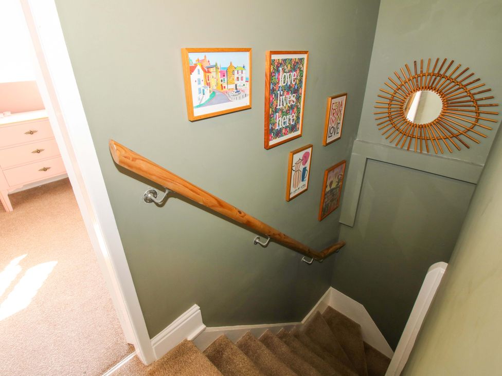 A staircase with pictures and a mirror at Cheshire Views in Malpas