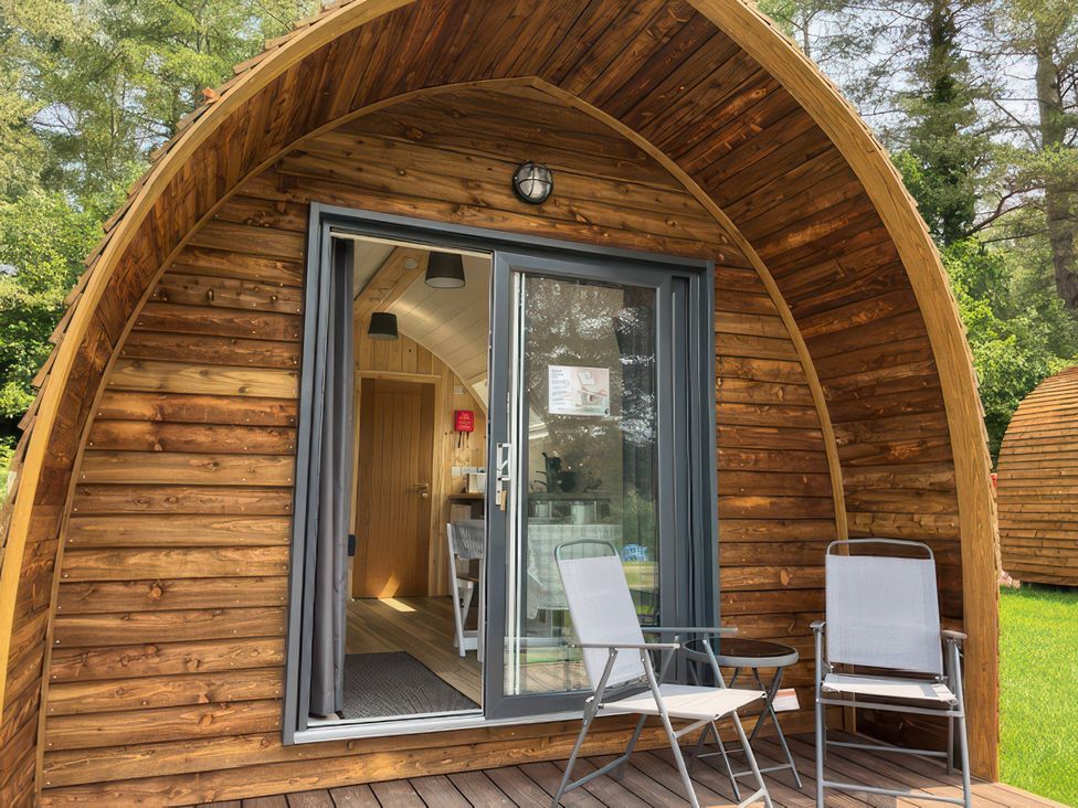 A wooden pod entrance with chairs and table outside at Bracelands - Cosy Pod 2 Coleford