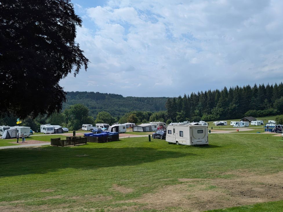 A campsite with multiple caravans and grassy areas at Bracelands - Cosy Pod 2, Coleford