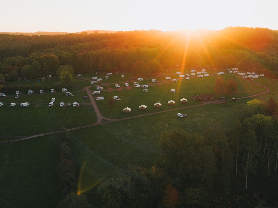 An aerial view of a camping site with caravans and tents at Bracelands - Cosy Pod 4, Coleford