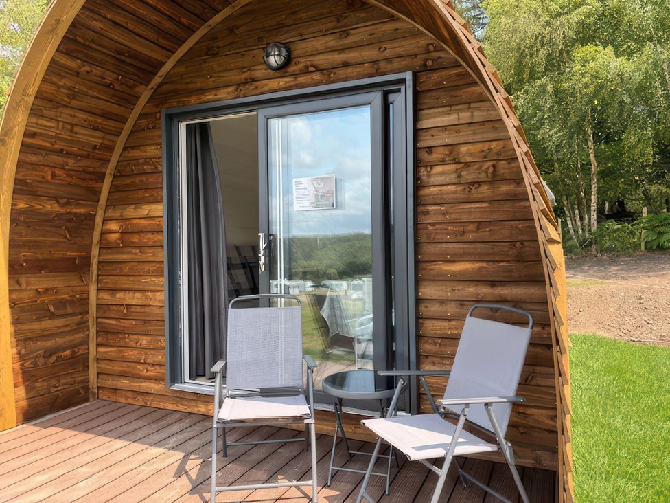 An outdoor seating area with chairs and a table at Bracelands - Cosy Pod 5 Coleford