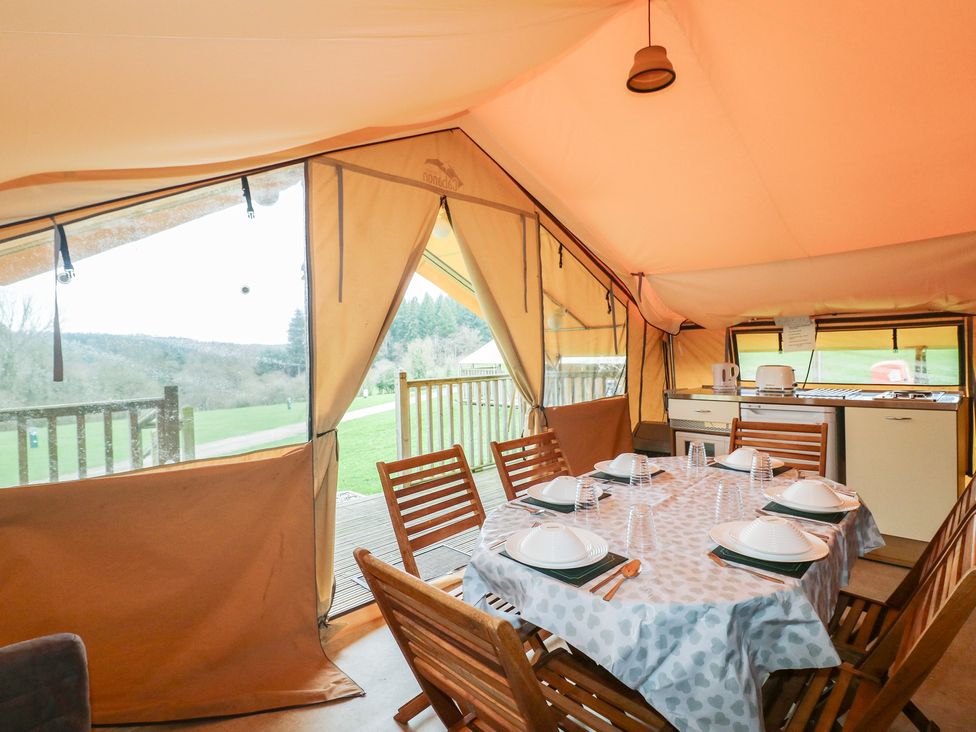 A dining area with a table and chairs at Bracelands - Safari Tent 1 in Coleford