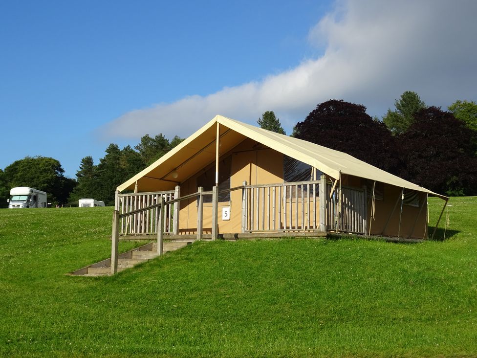 A tent with a wooden railing and stairs at Bracelands - Safari Tent 2, Coleford