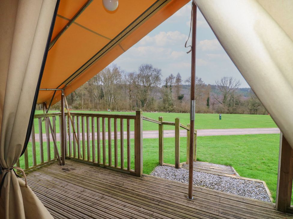 A view of a wooden deck with railing and gravel path at Bracelands - Safari Tent 2 near Coleford
