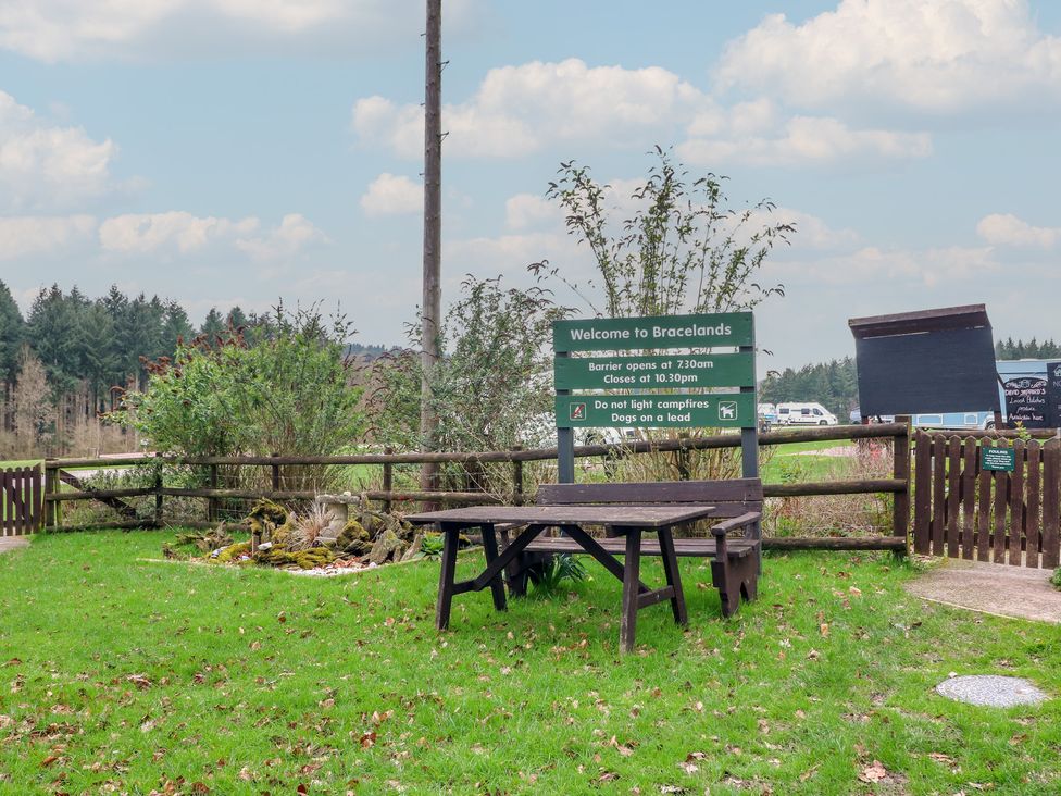 An outdoor area with a sign and a table at Bracelands - Safari Tent 5 Coleford