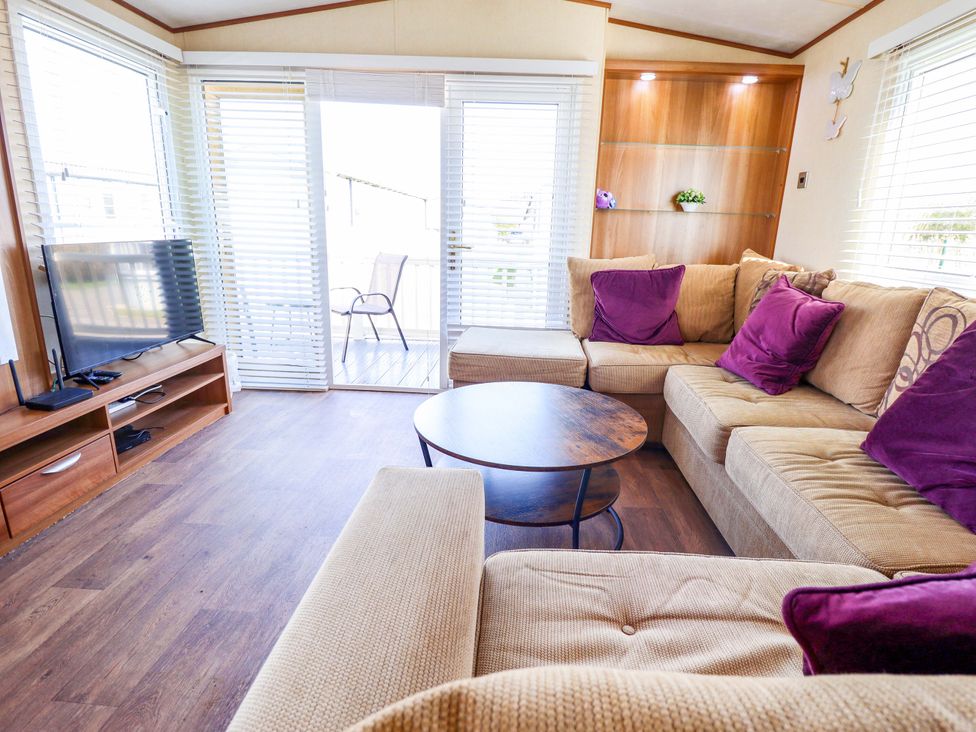 A living room with a television and sofa at Loopy’s Place - PG178, Chapel St Leonards