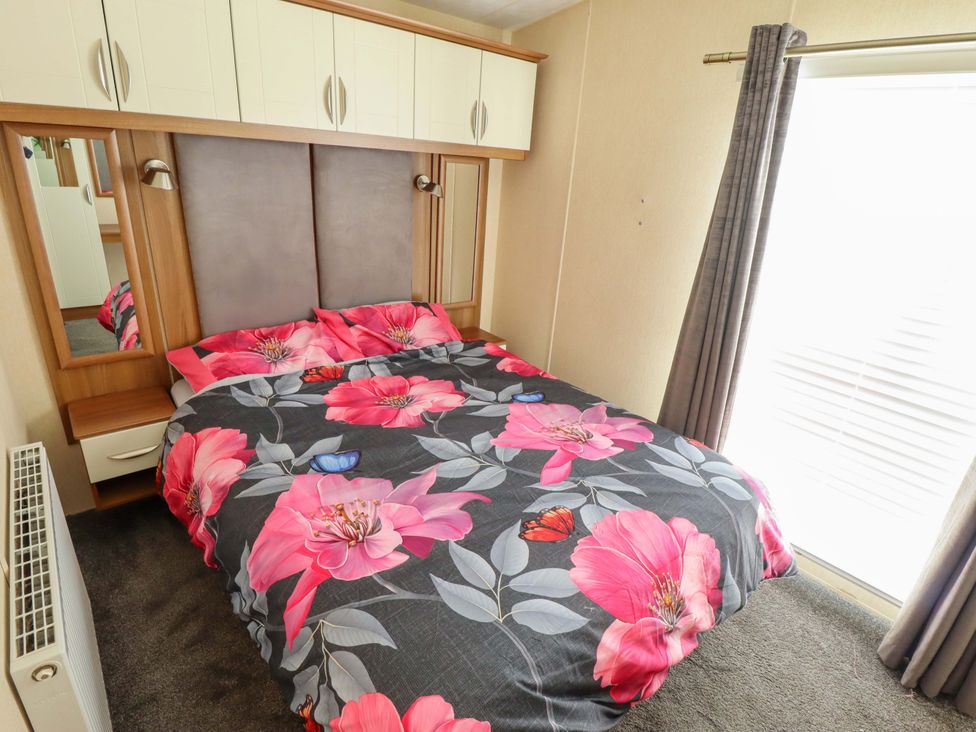 A bedroom with a bed and mirror at Loopy’s Place - PG178 in Chapel St Leonards