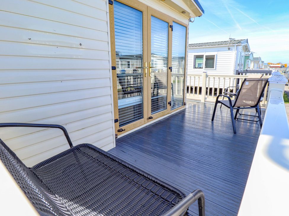 An outdoor deck with chairs at Loopy’s Place - PG178, Chapel St Leonards