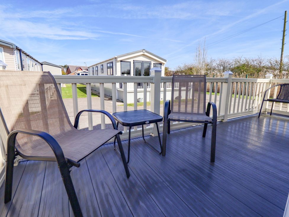 A deck area with two chairs and a table at Loopy’s Place - PG178 Chapel St Leonards