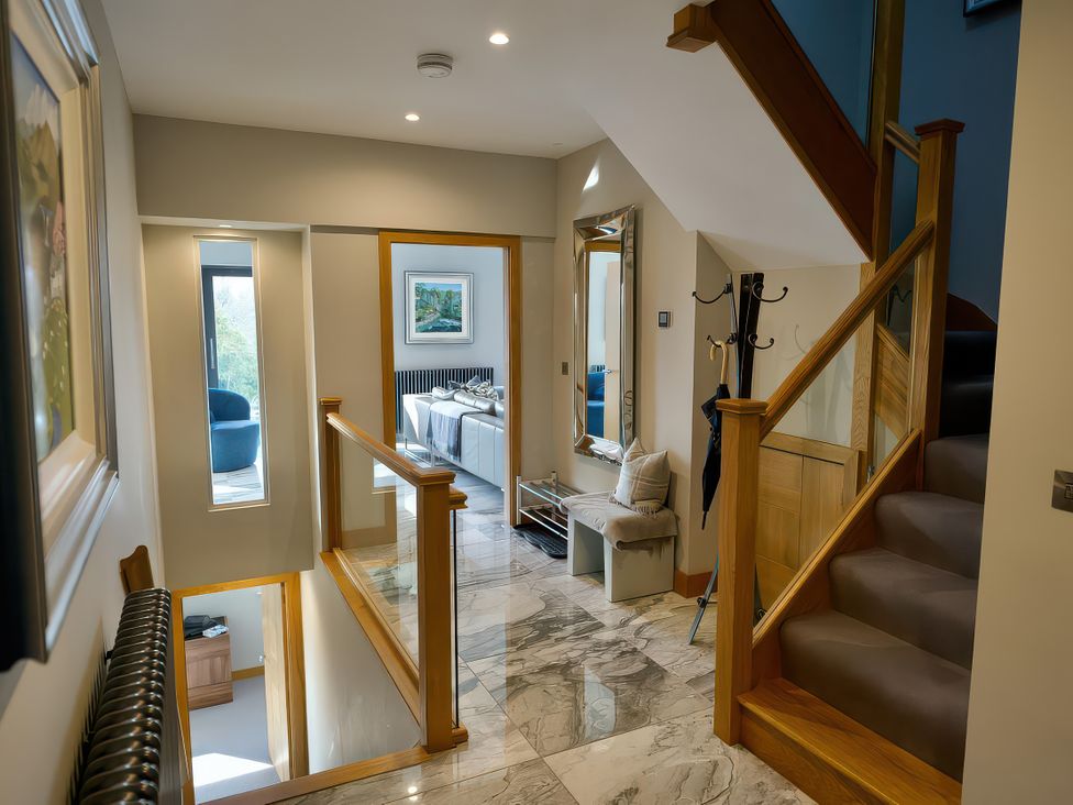 A hallway with a staircase and coat rack at Midways in Windermere
