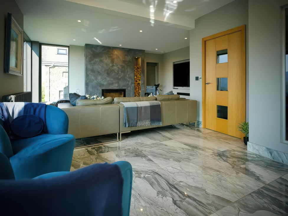 A living room with a sofa and fireplace at Midways, Bowness-On-Windermere