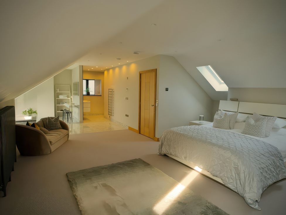 A bedroom with a bed and a sofa at Midways in Bowness-On-Windermere
