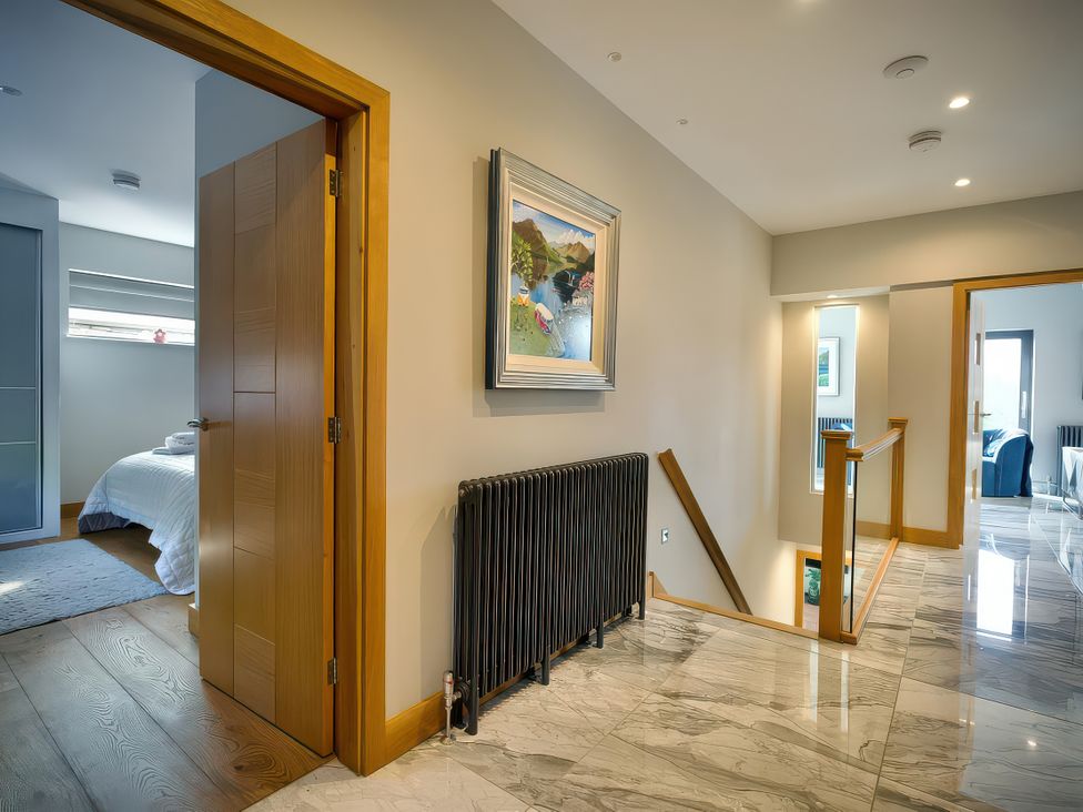 A hallway with a door and painting at Midways in Bowness-On-Windermere