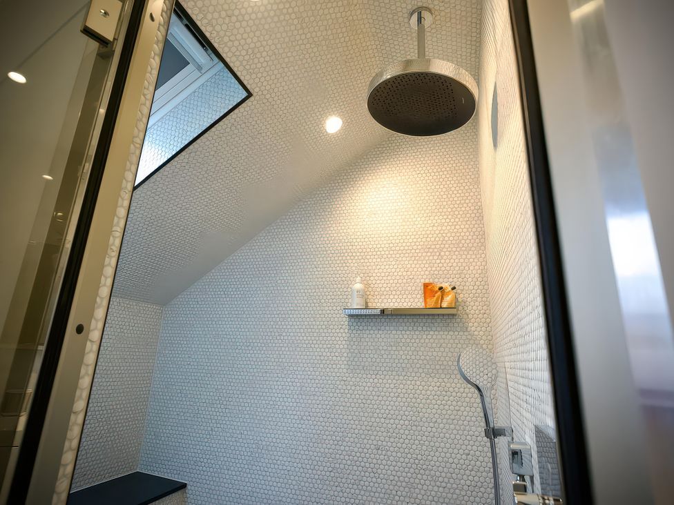 A shower area with tiled walls and a shelf at Midways in Bowness-On-Windermere