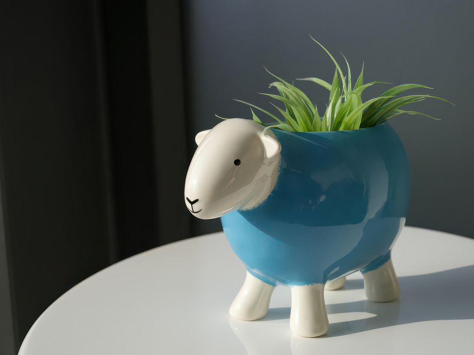 A sheep-shaped planter with grass on a table at Midways Bowness-On-Windermere