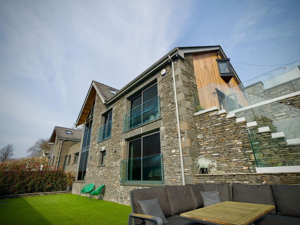 A house with a balcony and outdoor seating at Midways Bowness-On-Windermere