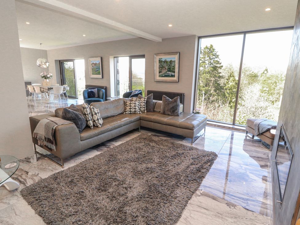 A living room with a sofa and large windows at Midways in Bowness-On-Windermere