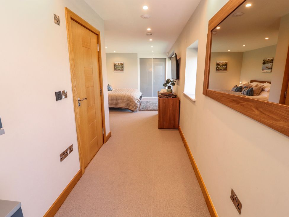 A bedroom with a bed and a wardrobe at Midways in Bowness-On-Windermere