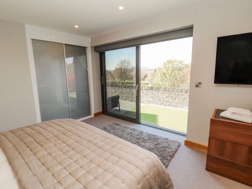 A bedroom with sliding doors and a view at Midways in Bowness-On-Windermere