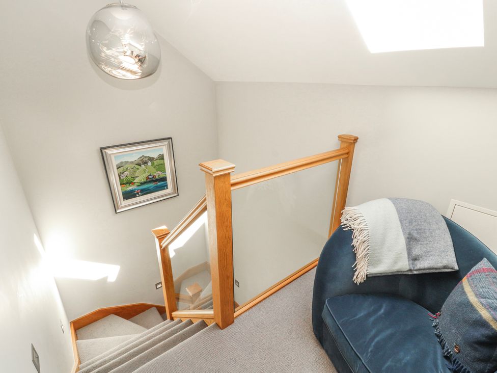 A staircase with a handrail and artwork at Midways in Bowness-On-Windermere