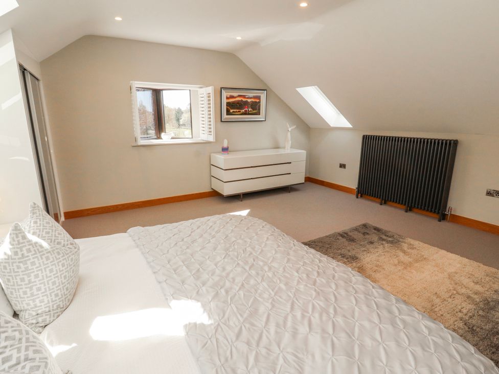 A bedroom with a bed and window at Midways in Bowness-On-Windermere