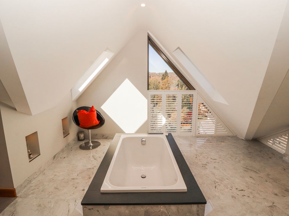 A bathroom with a bathtub and window at Midways in Bowness-On-Windermere
