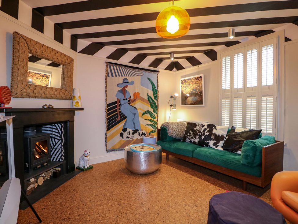 A snug with a green sofa and wall art at 3 Cinque Ports Street in Rye