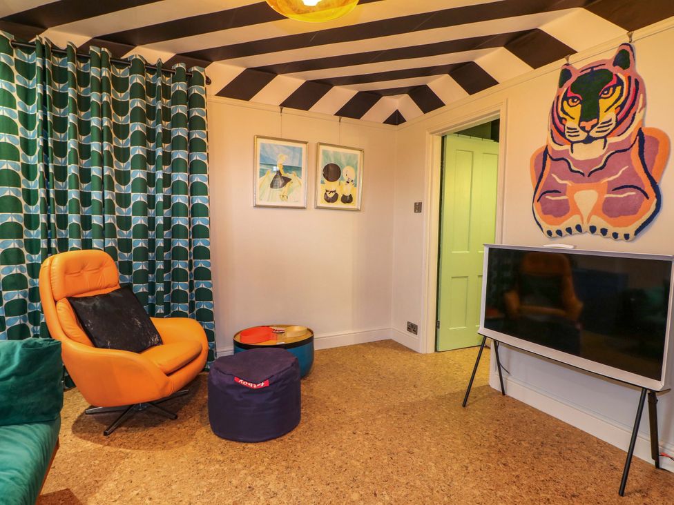 A sitting room with an armchair and tv at 3 Cinque Ports Street, Rye