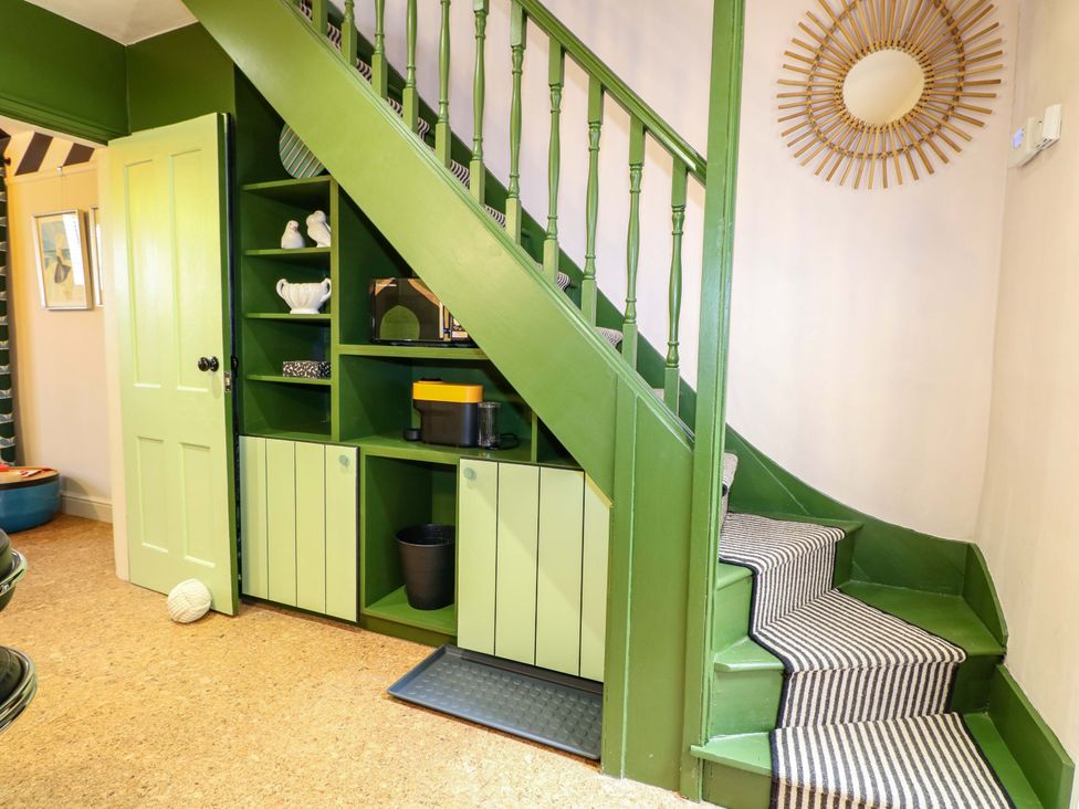 A hallway with stairs and storage unit at 3 Cinque Ports Street Rye