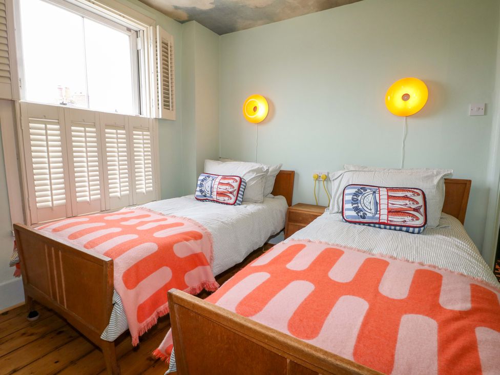 A bedroom with two beds and a window at 3 Cinque Ports Street Rye