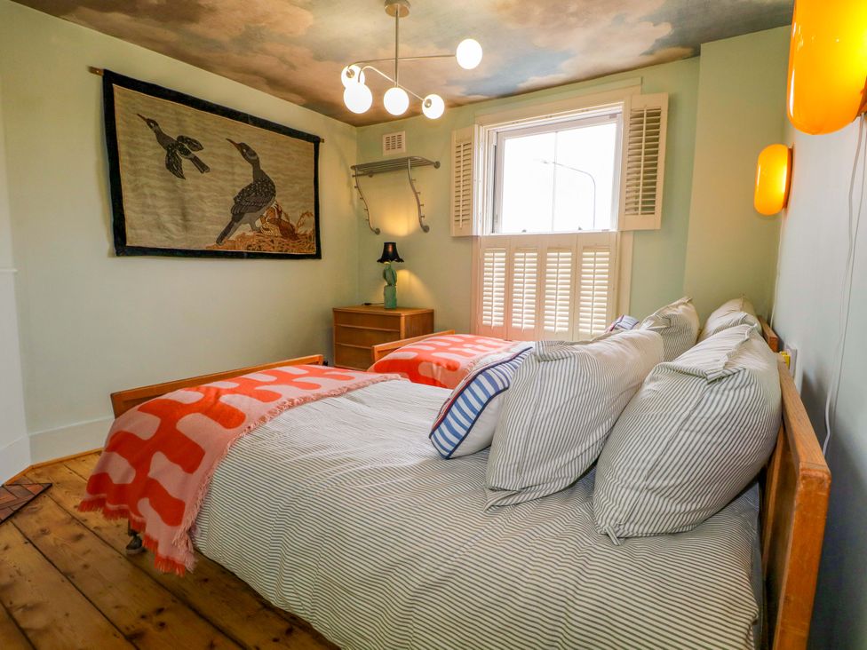 A bedroom with a bed, pillows, and an artwork at 3 Cinque Ports Street, Rye