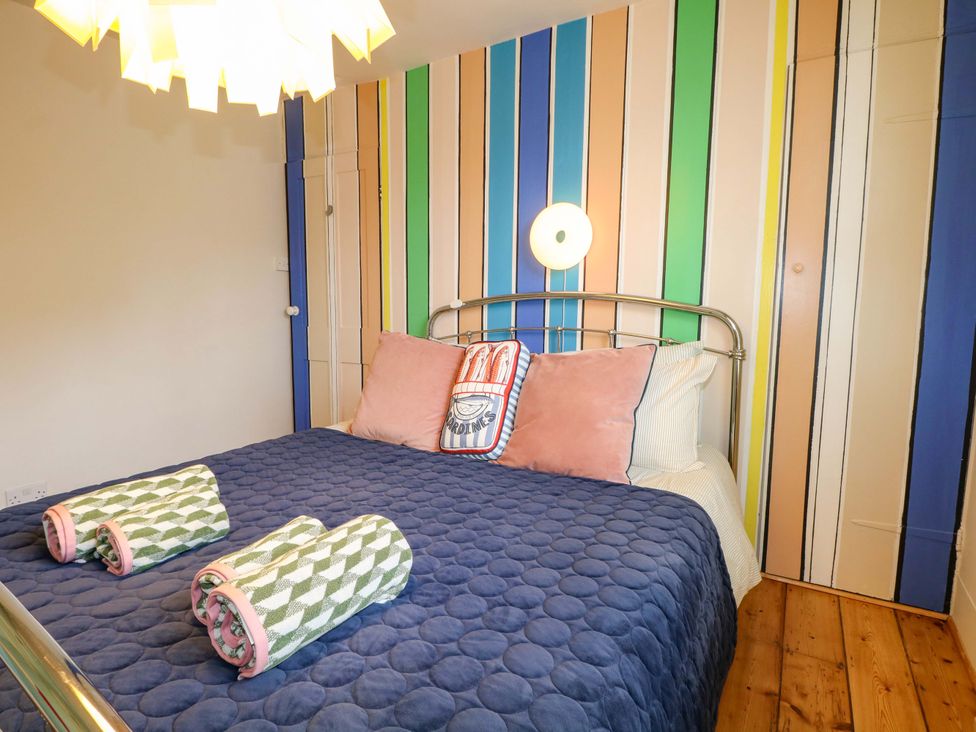 A bedroom with a bed and decorative pillows at 3 Cinque Ports Street, Rye