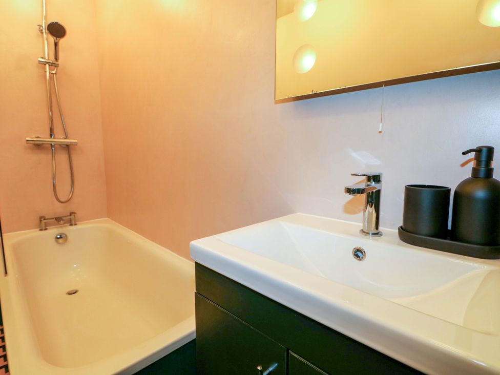 A bathroom with a bathtub and sink at 3 Cinque Ports Street in Rye