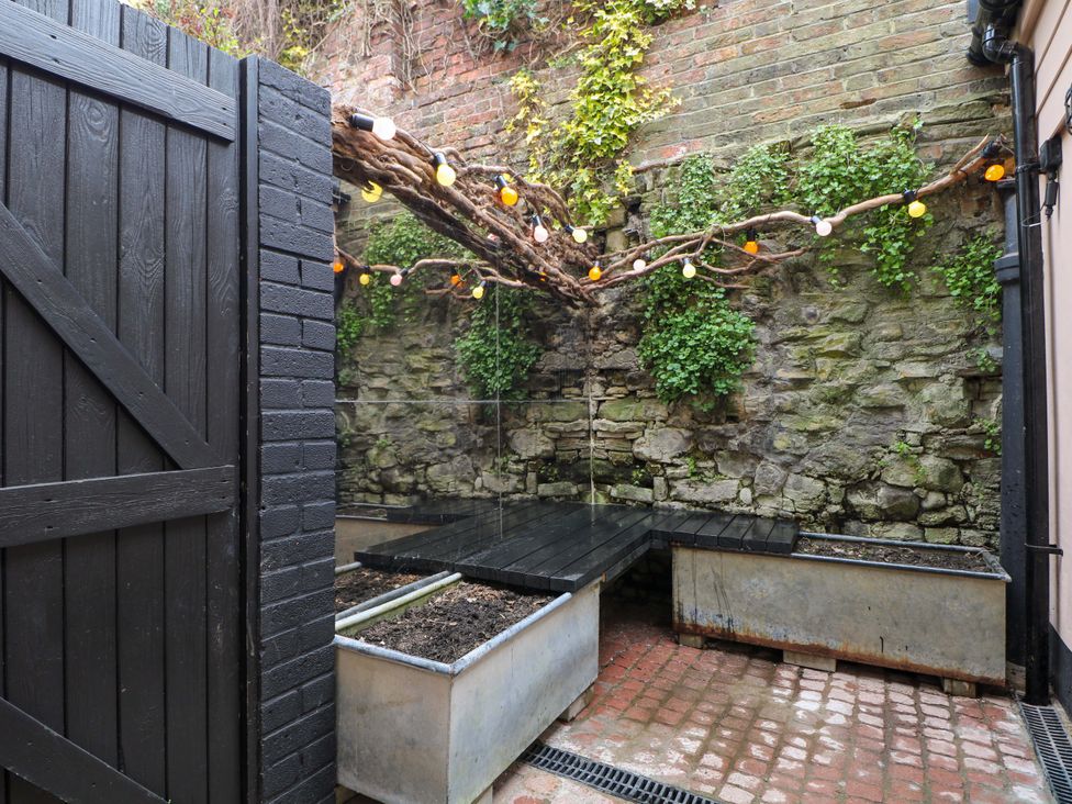 A garden with planters and lights at 3 Cinque Ports Street, Rye